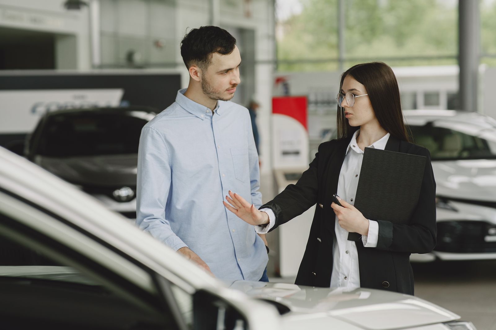 Woman Selling Car to Client in Salon Woman Selling Car to Client in Salon