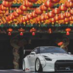 White sports car parked under festive lanterns