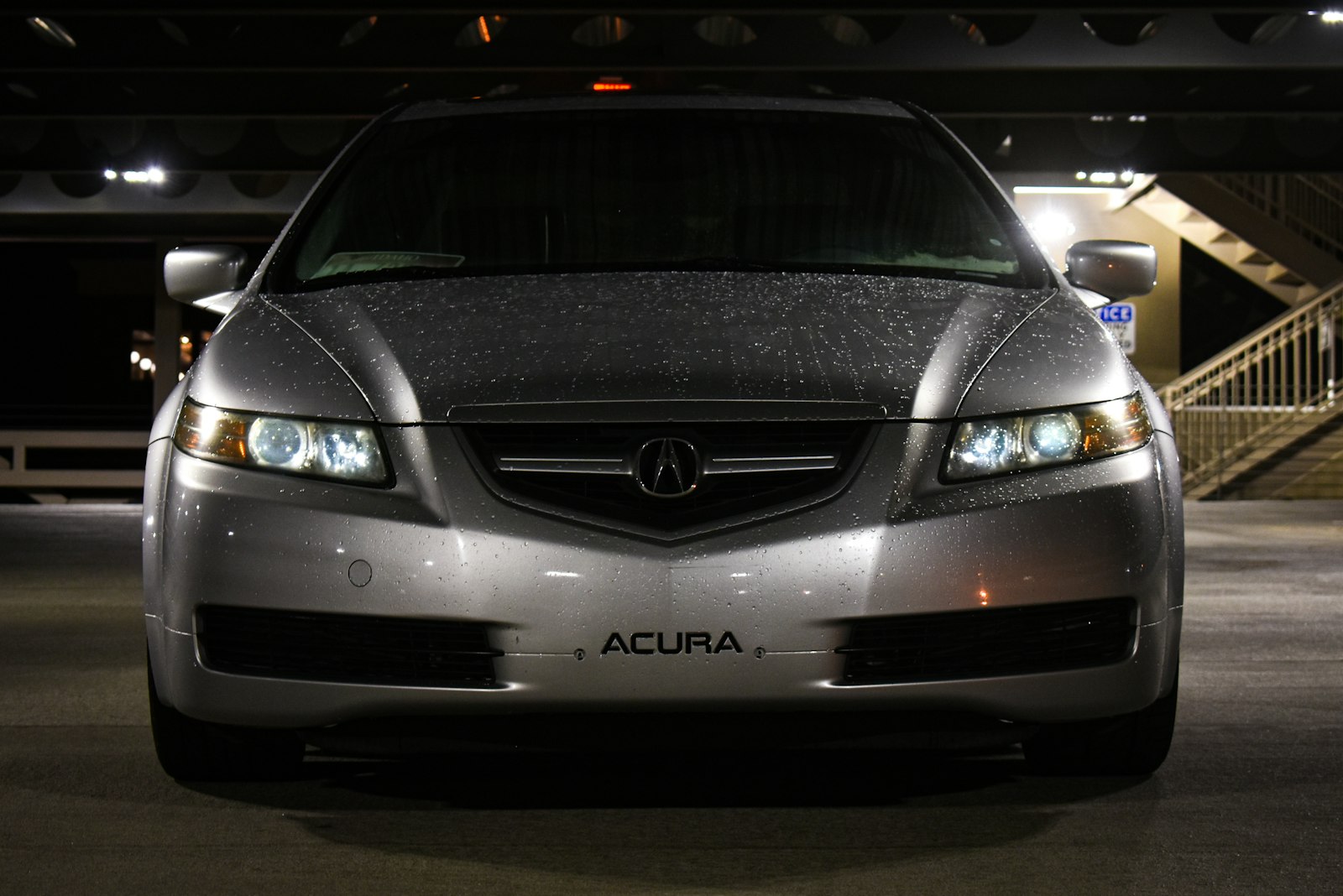 a silver acura car parked in a parking garage