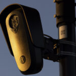 Flock Safety surveillance camera mounted on a pole at dusk