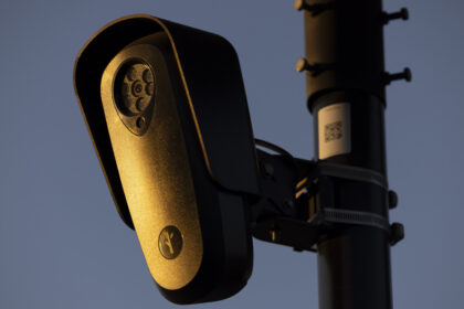 Flock Safety surveillance camera mounted on a pole at dusk