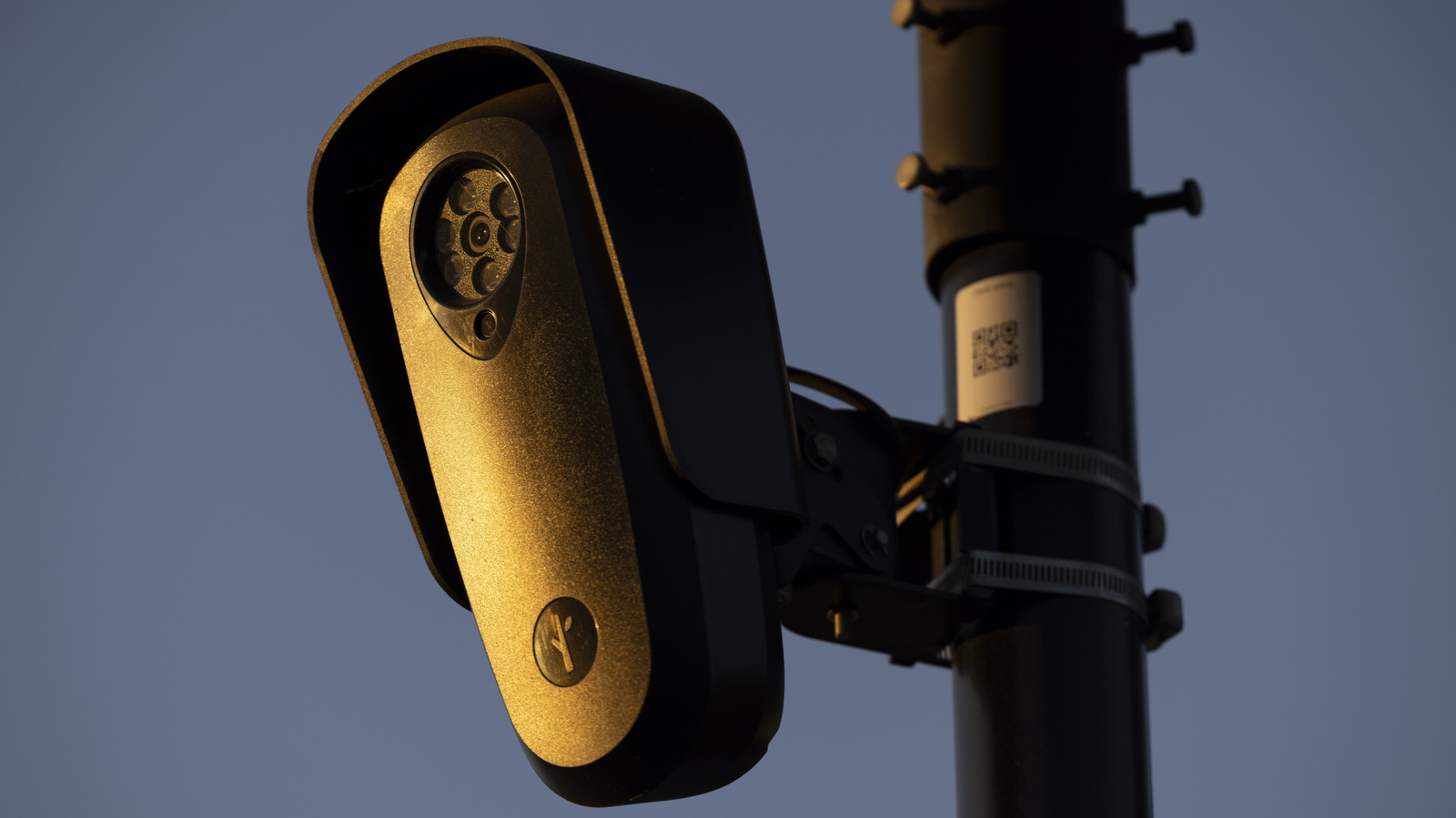 Flock Safety surveillance camera mounted on a pole at dusk