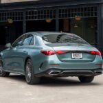 Rear three-quarter view of a teal Mercedes-Benz E450 sedan parked outdoors