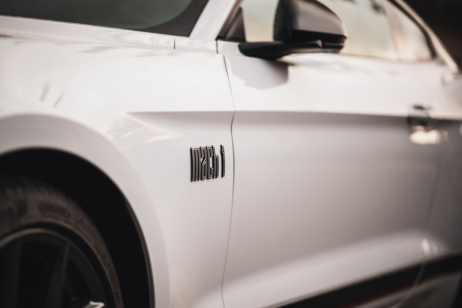 Close-up of white Ford Mustang Mach 1 fender badge