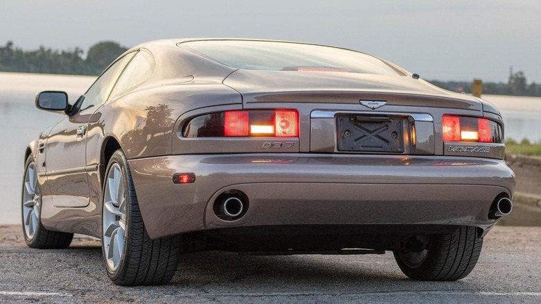 Brown Aston Martin DB7 Vantage rear view parked near water