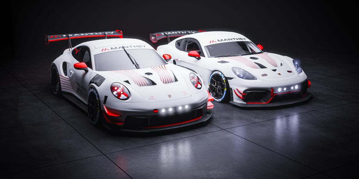 Two Manthey-liveried Porsche race cars on dark studio floor