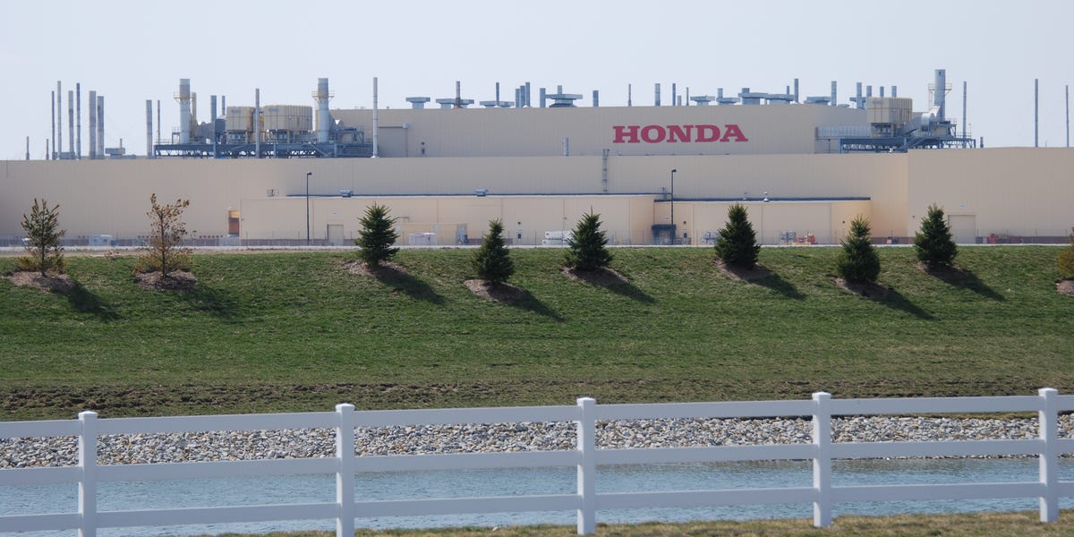 Honda manufacturing plant exterior with red logo and industrial equipment