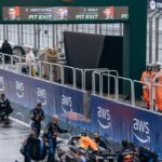 Red Bull pit crew working on Verstappen's car in wet Bahrain pit lane