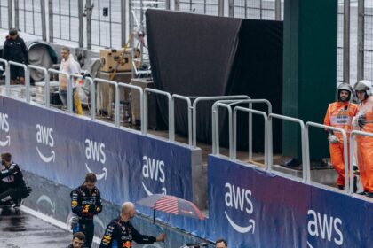 Red Bull pit crew working on Verstappen's car in wet Bahrain pit lane