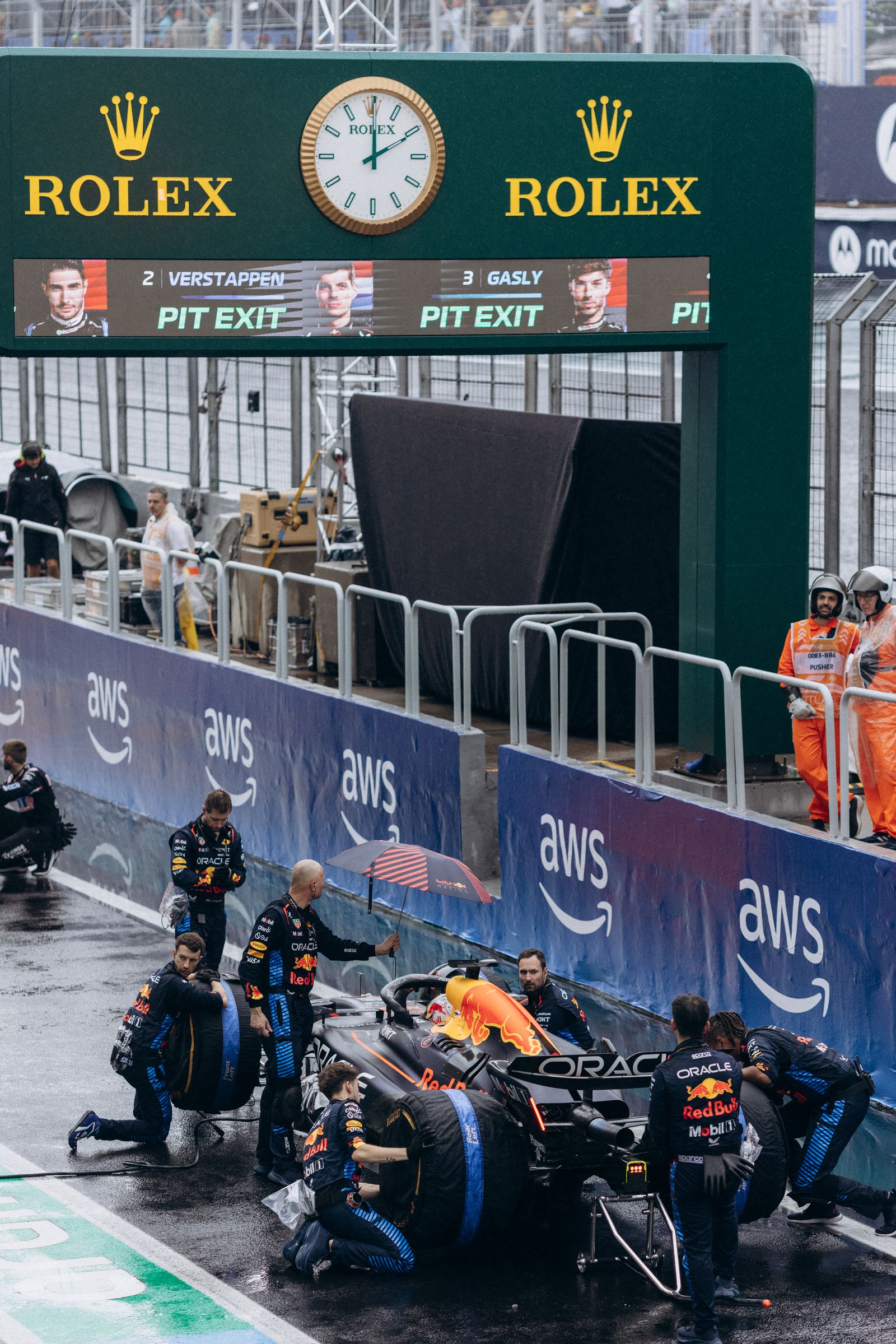 Red Bull pit crew working on Verstappen's car in wet Bahrain pit lane
