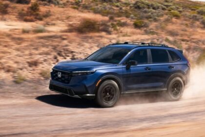 Blue Honda CR-V driving on a dusty dirt road