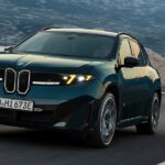 Dark green BMW SUV driving on a winding mountain road