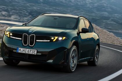 Dark green BMW SUV driving on a winding mountain road