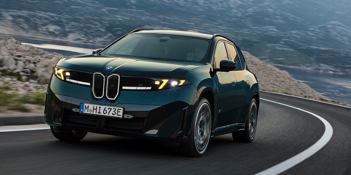 Dark green BMW SUV driving on a winding mountain road