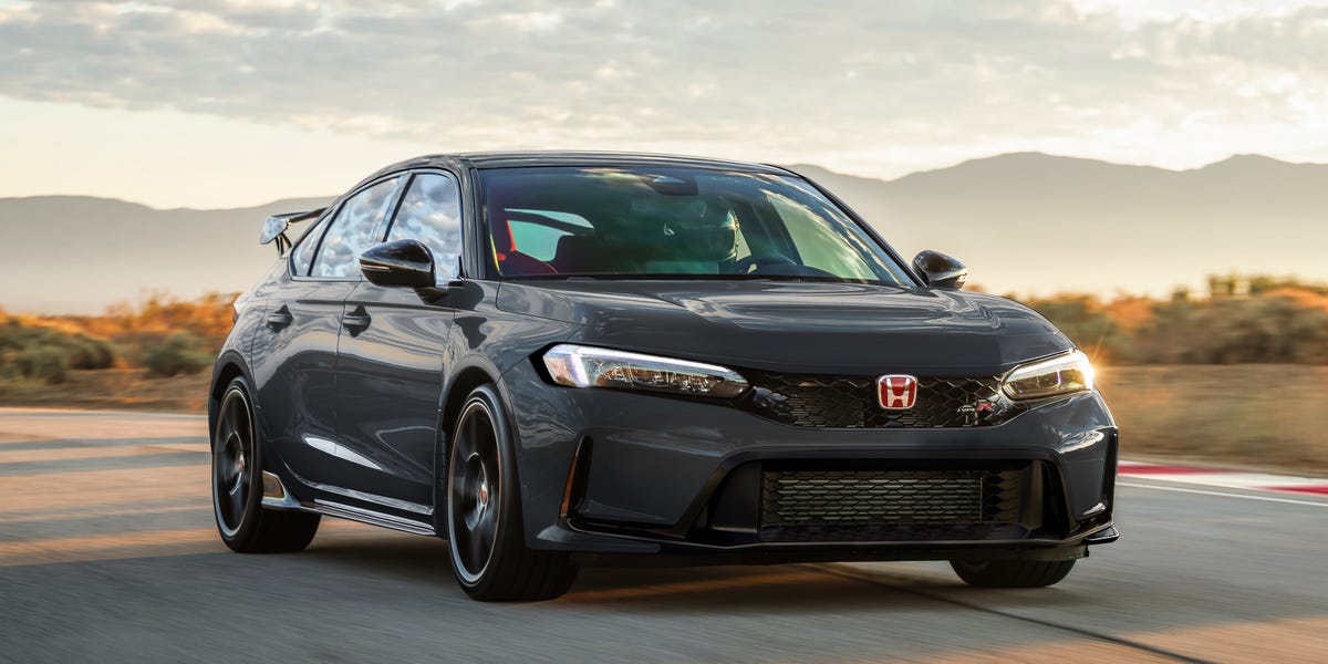 Dark gray Honda Civic Type R driving on a road at sunset
