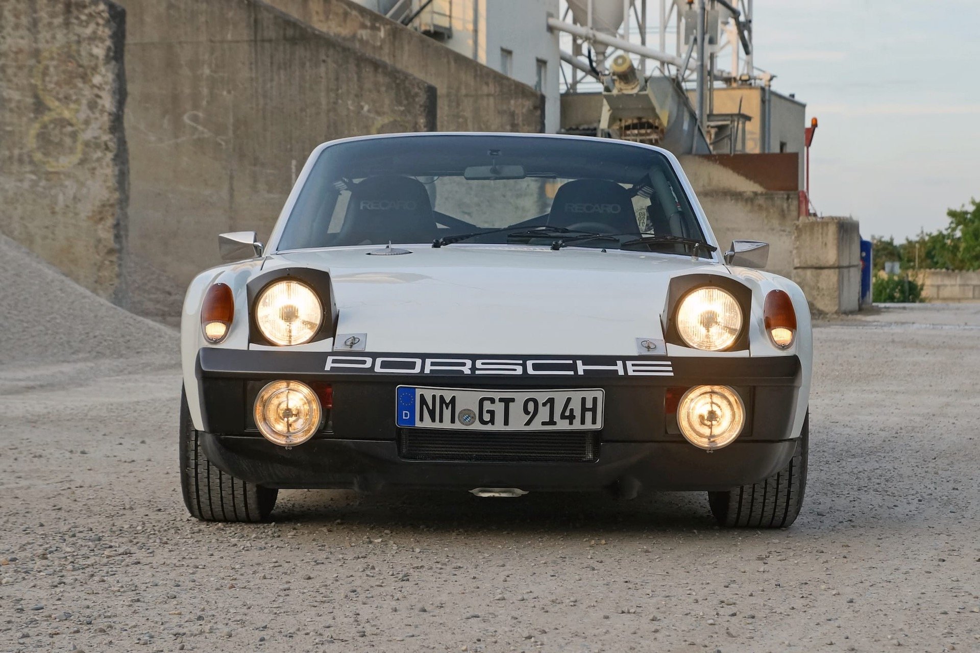 White Porsche 914 with pop-up headlights and fog lights on