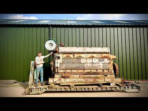 Massive industrial engine with man standing beside it for scale
